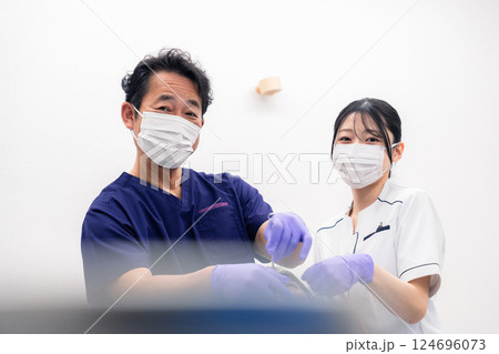 歯科治療をする歯科医師と歯科助手 124696073