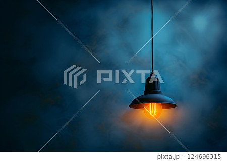 Close up of an incandescent lamp s bright glow set against a rich deep blue background 124696315