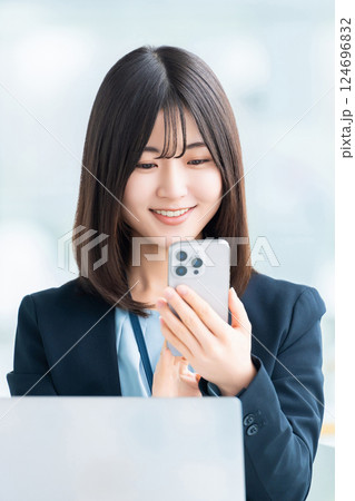スマートフォンを使う笑顔の女性・ビジネスウーマン 124696832