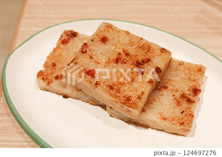 close up of Cantonese dim sum three pieces of turnip cake ( Chinese Lo Pak Go) on a white plate 124697276