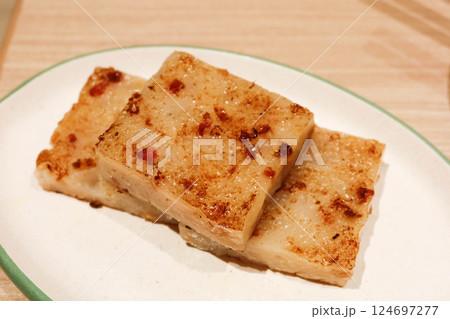 close up of Cantonese dim sum three pieces of turnip cake ( Chinese Lo Pak Go) on a white plate close up of Cantonese dim sum three pieces of turnip cake ( Chinese Lo Pak Go) on a white plate 124697277