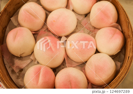 close up of steamed many Chinese steamed Birthday Peach Buns (longevity bun) stuffed with sweetened lotus seed paste in a bamboo steamer for celebrating birthday close up of steamed many Chinese steamed Birthday Peach Buns (longevity bun) stuffed with sweetened lotus seed paste in a bamboo steamer for celebrating birthday 124697289