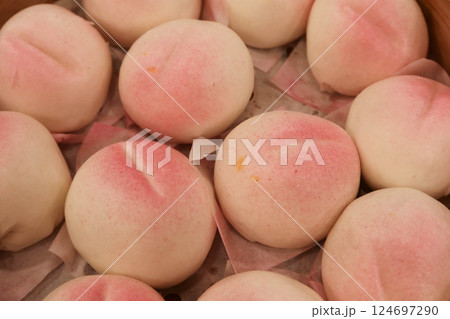 close up of steamed many Chinese steamed Birthday Peach Buns (longevity bun) stuffed with sweetened lotus seed paste in a bamboo steamer for celebrating birthday 124697290