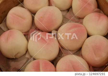 close up of steamed many Chinese steamed Birthday Peach Buns (longevity bun) stuffed with sweetened lotus seed paste in a bamboo steamer for celebrating birthday 124697291