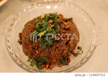 Close up of stir fried Chinese sausage sticky rice (glutinous rice) with peanuts and spring onion on a glass plate Close up of stir fried Chinese sausage sticky rice (glutinous rice) with peanuts and spring onion on a glass plate 124697352