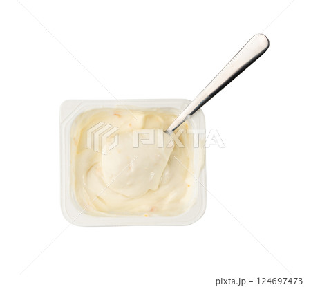 Yogurt cup isolated, yoghurt with orange fruits pieces in plastic pot, spoon in milk pudding 124697473
