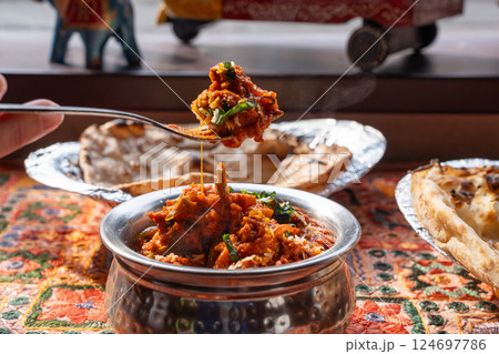 Lamb curry with tomatoes and fiery chili, traditional Indian Laal Maas served in a metal dish Lamb curry with tomatoes and fiery chili, traditional Indian Laal Maas served in a metal dish 124697786