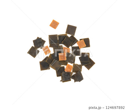 Dry kelp seaweed squares, mini wakame pieces isolated, dried kombu and carrot flakes from ramen Dry kelp seaweed squares, mini wakame pieces isolated, dried kombu and carrot flakes from ramen 124697892