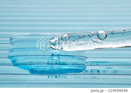 Serum in a pipette on a blue ribbed background. Serum in a pipette on a blue ribbed background. 124698046