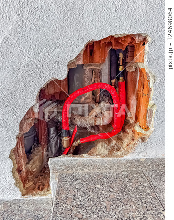 Exposed Plumbing Pipes in Damaged Wall, Construction Repair, Home Maintenance Work. High quality photo Exposed Plumbing Pipes in Damaged Wall, Construction Repair, Home Maintenance Work. High quality photo 124698064