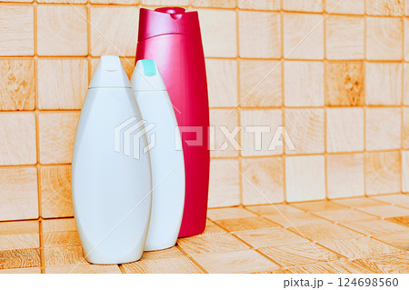 Plastic white red detergent bottles on tiled bath surface Plastic white red detergent bottles on tiled bath surface 124698560