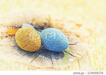 Yellow and blue Easter eggs on a wooden stump Yellow and blue Easter eggs on a wooden stump 124698576