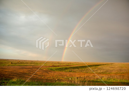 Evening sunset rainbow over the field. 124698720