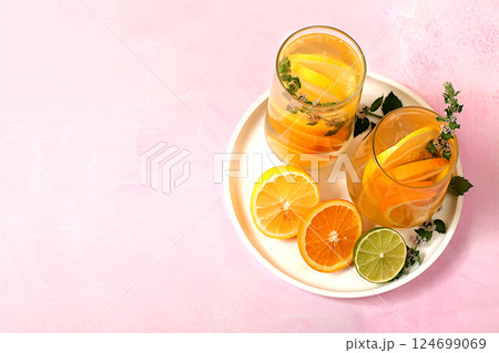 Detox drink with lemon, mint, lime and orange on a light table, mojito or cocktail improves metabolism, promotes weight loss and strengthens immunity, healthy lifestyle concept, selective focus. Detox drink with lemon, mint, lime and orange on a light table, mojito or cocktail improves metabolism, promotes weight loss and strengthens immunity, healthy lifestyle concept, selective focus. 124699069