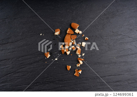 Crushed almonds, nut pieces, sliced scattered almond seeds and cut kernels collection on black background 124699361