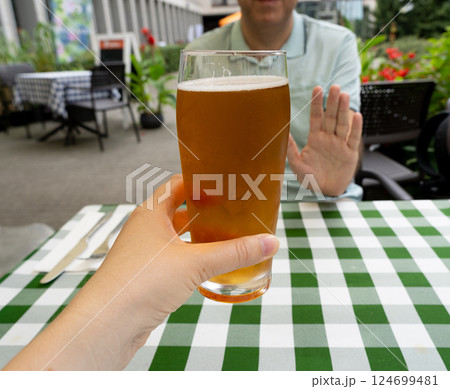Reject a glass of beer, man refusing alcohol, stop drinking, sobriety concept, saying no to beer glass 124699481