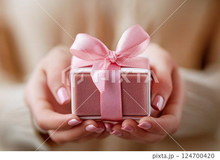 Woman hands holding pink gift satin ribbon, shopping Valentines, New Year, Mothers, Christmas 124700420