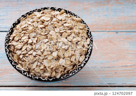 Bowl of Oat Flakes on Wooden Background, Healthy Eating Concept, Copy Space 124702097