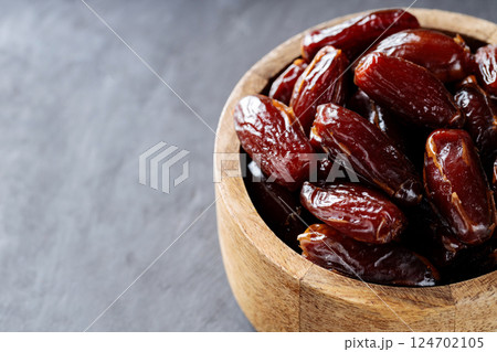 Dried Dates in Wooden Bowl on Dark Background, Top View, Copy Space 124702105
