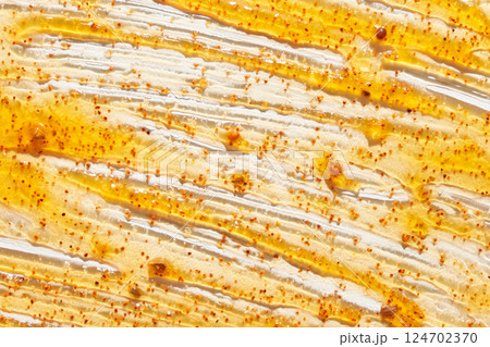 Honey and mustard sauce spread with mustard seeds on white surface in close up 124702370