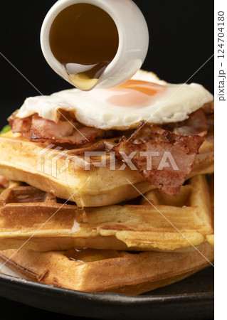 ワッフルとベーコンエッグの朝食 ワッフルにはちみつをかける ワッフルとベーコンエッグの朝食 ワッフルにはちみつをかける 124704180