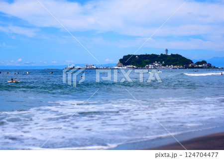 サーファーが波と戯れる夏真っ盛りの湘南・鎌倉の海と、美しい江ノ島の風景で、夏休みのイメージ サーファーが波と戯れる夏真っ盛りの湘南・鎌倉の海と、美しい江ノ島の風景で、夏休みのイメージ 124704477
