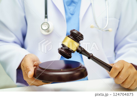 Asian doctor holding court hammer for and crime law justice, forensic medicine. Asian doctor holding court hammer for and crime law justice, forensic medicine. 124704875