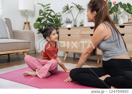 Mother-Daughter Meditation Moment. A mother and her daughter sharing a calm meditation session on a yoga mat. 124704893
