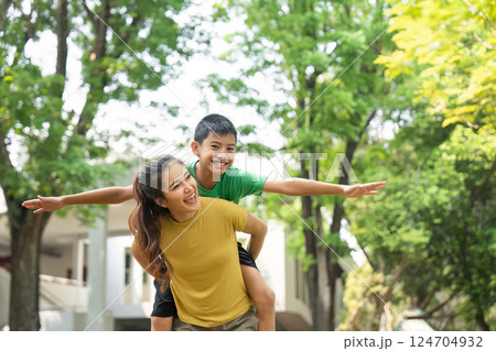 Playfulness and Recreation. A mother and son enjoying playful moments outdoors, sharing laughter and fun. 124704932