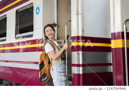Travel Journey and Boarding Experience. A woman joyfully preparing to board a train, full of enthusiasm for her trip. 124704946