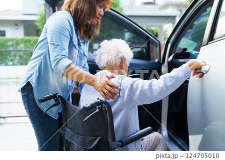 Caregiver help Asian elderly woman disability patient use wheelchair to get in car. 124705010