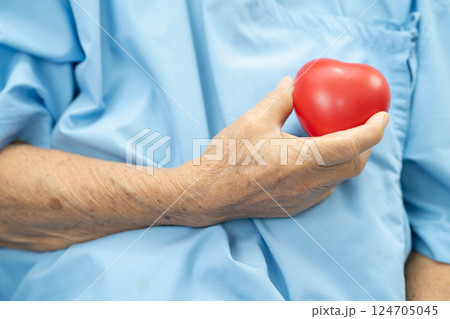 Asian elder senior woman patient holding red heart in hospital. Asian elder senior woman patient holding red heart in hospital. 124705045