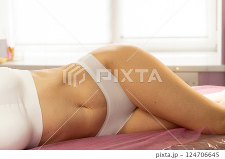 Woman in white activewear lies on side during spa session 124706645
