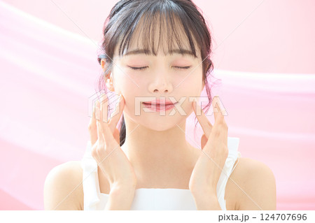 ピンク背景で撮影をした若い女性の爽やかな美容イメージ 124707696