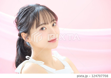ピンク背景で撮影をした若い女性の爽やかな美容イメージ 124707708