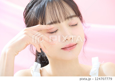 ピンク背景で撮影をした若い女性の爽やかな美容イメージ 124707779