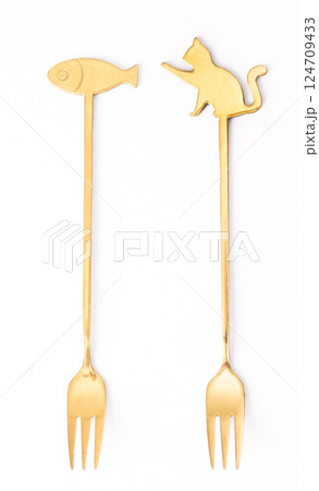 Elegant gold appetizer forks with cat and fish designs on a white background, for stylish dining and tableware. 124709433