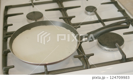 Cooking delicious crepes on a gas stove using a nonstick frying pan requires skill and practice Cooking delicious crepes on a gas stove using a nonstick frying pan requires skill and practice 124709983