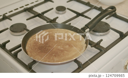 Enjoying the delicious and appetizing pancake being cooked on the stove for breakfast Enjoying the delicious and appetizing pancake being cooked on the stove for breakfast 124709985