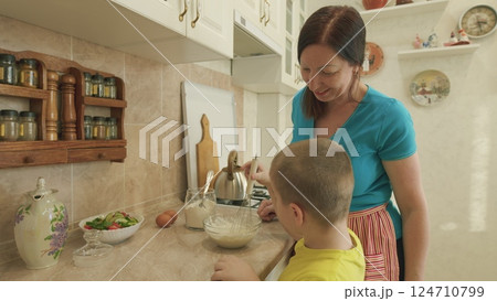 A Mother and her Son Enjoy Cooking Together in a Bright and Cheerful Kitchen Space 124710799