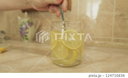 Enjoying Refreshing Lemon Water Served in a Beautiful Glass Jar Perfect for Summer Days Enjoying Refreshing Lemon Water Served in a Beautiful Glass Jar Perfect for Summer Days 124710836
