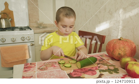 A child happily preparing a healthy snack in the warm, inviting kitchen environment A child happily preparing a healthy snack in the warm, inviting kitchen environment 124710911