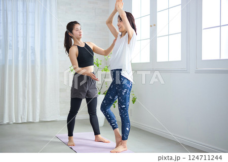 ヨガインストラクターにレッスンを受けるミドル女性 124711244