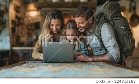 Adventure planning: family exploring travel destinations with laptop and map in cozy cabin interior 124713168