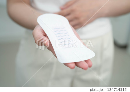 Asian woman holding sanitary napkin pad for hygiene menstrual period cycle protection. 124714315