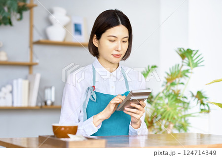 家計簿をつけるエプロン姿の若い主婦 124714349