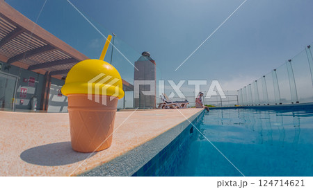 Tourist relaxing by the rooftop pool with refreshing drink on summer day Tourist relaxing by the rooftop pool with refreshing drink on summer day 124714621