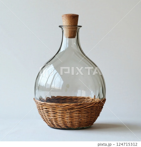Vintage glass decanter with wicker base and cork stopper for rustic home decor and elegant table setting 124715312