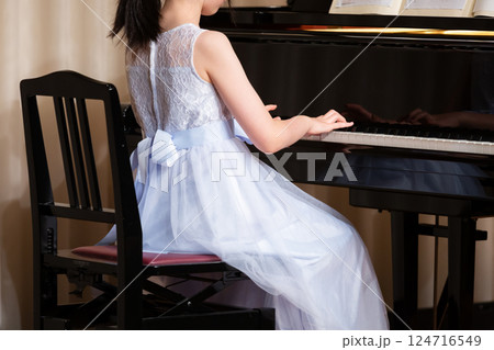 ドレスを着てピアノを弾く女の子の後ろ姿 124716549