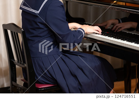 ピアノを弾くセーラー服の女子学生の手元 124716551